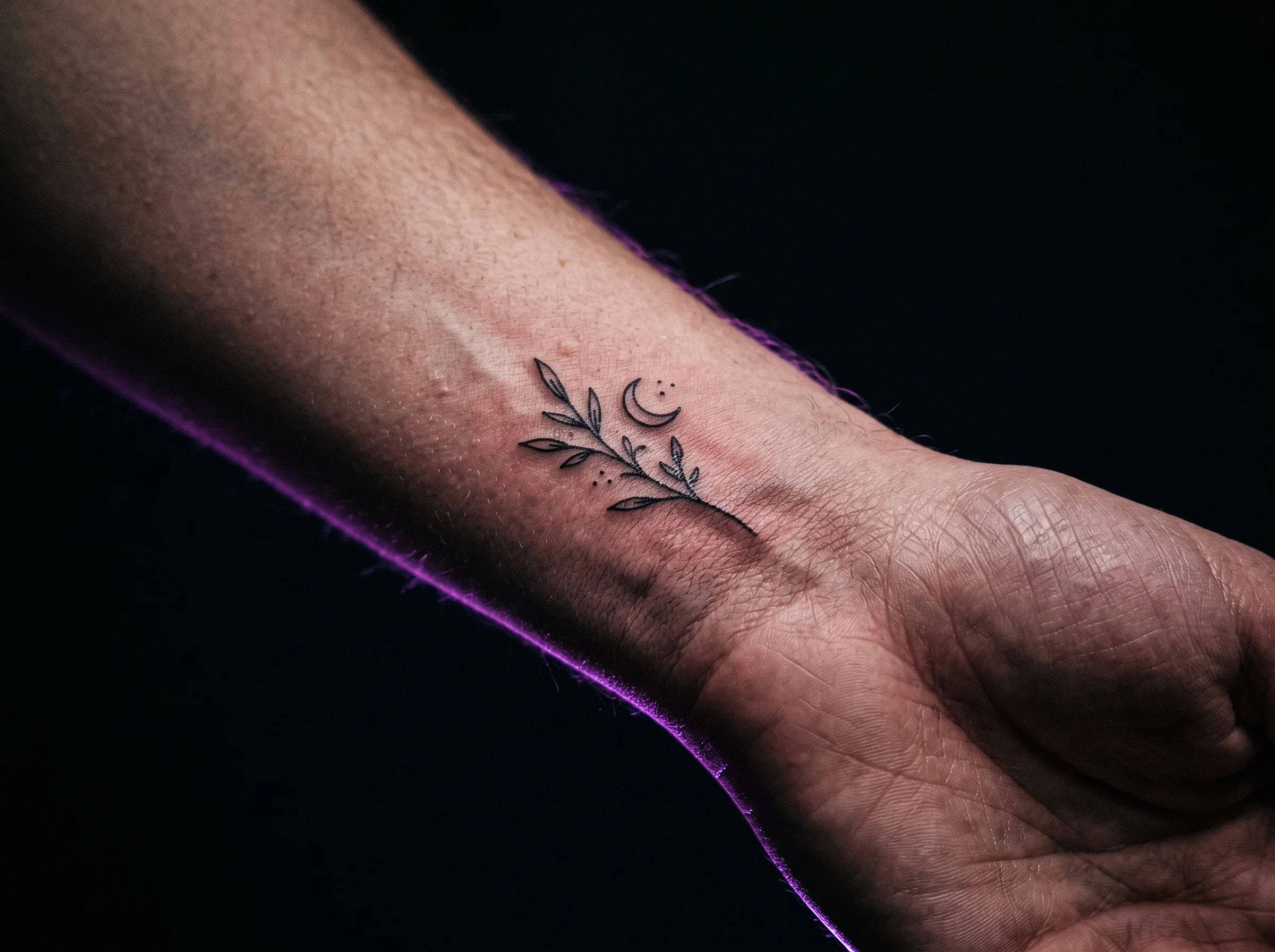Macro detail of fine-line tattoo linework on inner wrist skin