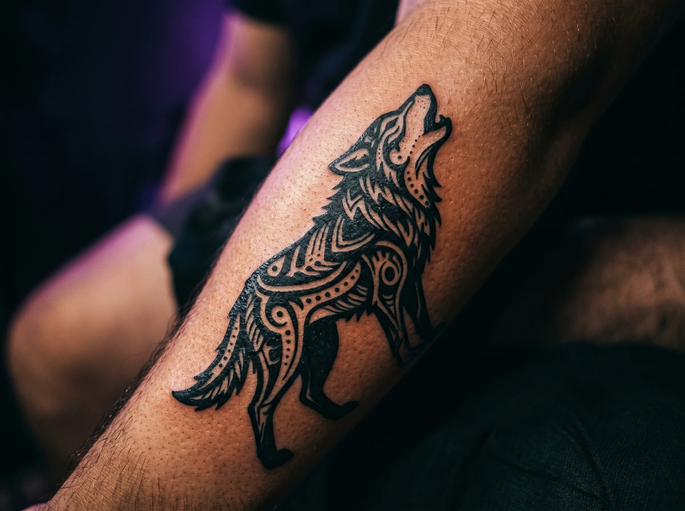 Bold blackwork-style animal silhouette tattoo on forearm skin